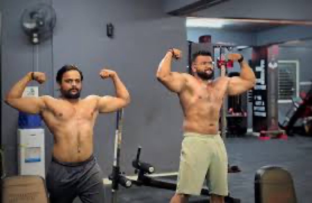 Two BurnZone coaches flexing — competition-level physiques